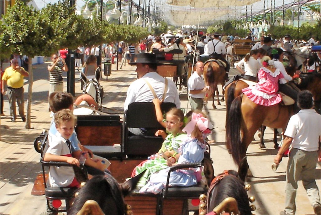 Niños y niñas paseando en calesa por la Feria de Málaga