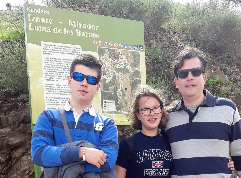 Delante del cartel de la ruta al Mirador Loma de Barcos en Iznate, Málaga