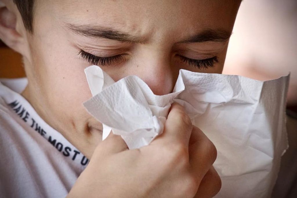 Niño sonándose la nariz