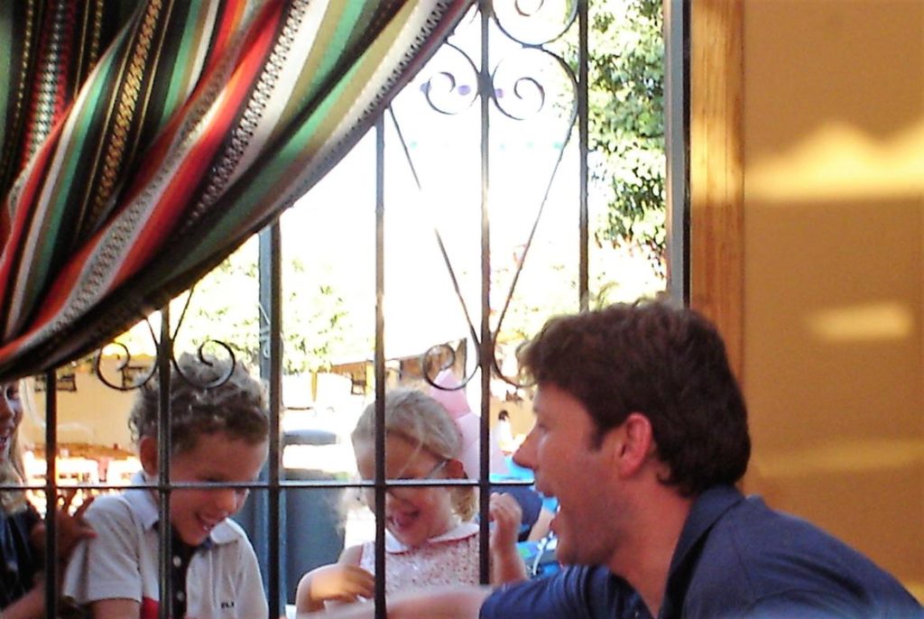 Padre jugando con niños en una caseta de la feria
